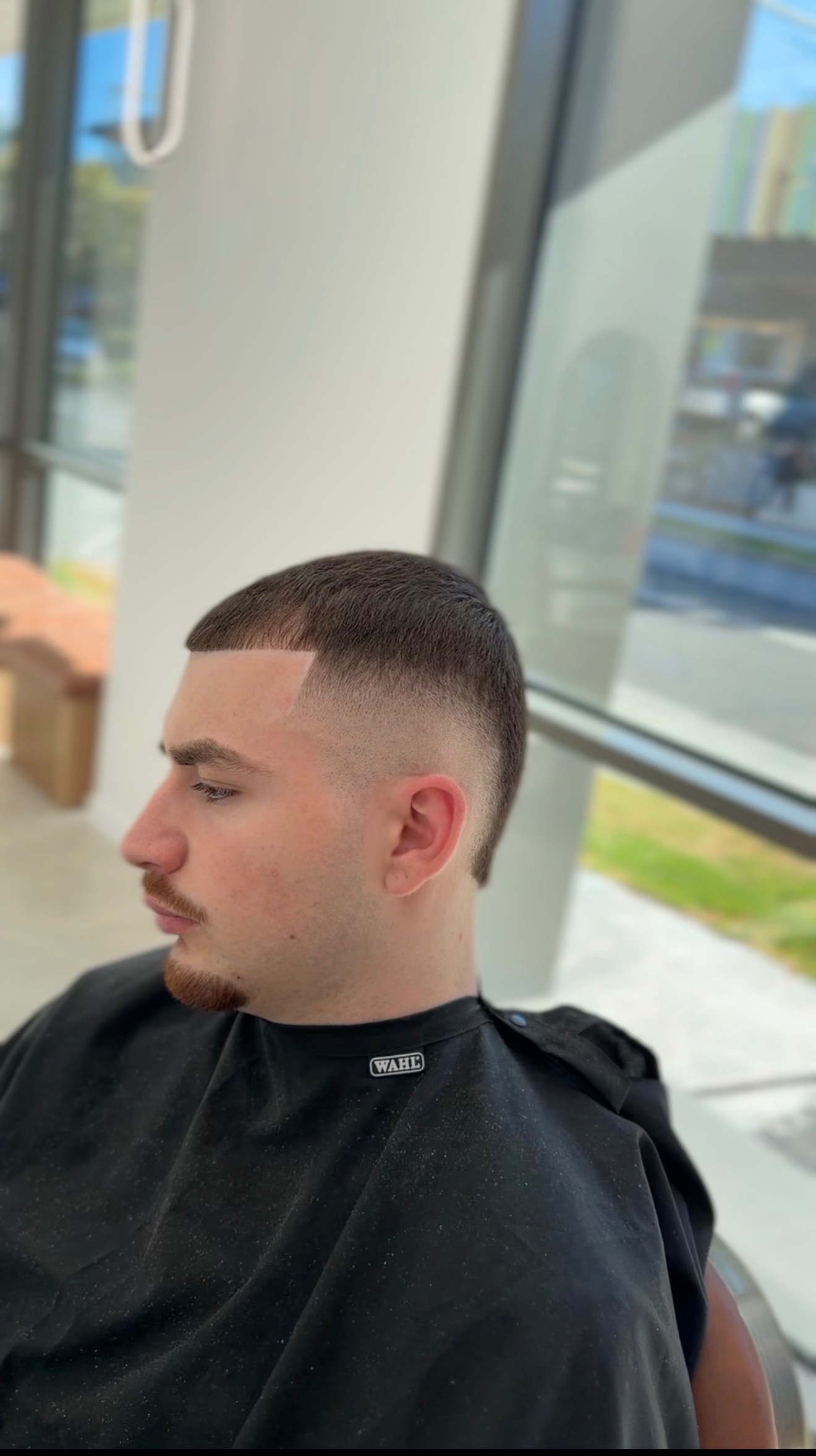 Side profile of a smooth mid fade and short haircut